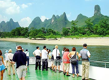 游客们在游船上欣赏漓江的美景